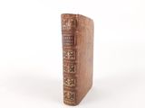 an old book that is sitting on a white surface