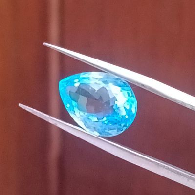 une image représentant un diamant bleu tenu par une paire de pinces