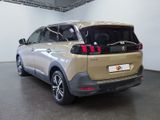 the rear end of a beige car parked in a garage