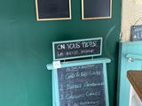 un tableau noir sur lequel est inscrit un menu, devant un mur vert