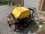 une petite machine jaune qui est posée sur le gravier