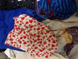 a pile of clothes that is sitting on a bed