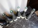 six bottles of wine sitting on a table next to each other