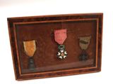 a picture of a shadow box with three medals in it