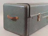 a green suitcase sitting on top of a white table
