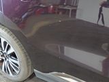 a close up of a car with a person taking a picture of it