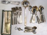 a lot of silverware on a table with a case