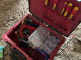 a red case with tools in it sitting on the ground