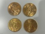 quatre pièces d'or posées sur une surface blanche