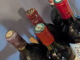 several bottles of wine sit on a wooden tray on a table