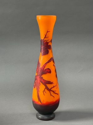 a vase with a bird design on it sitting on a table