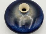 a blue and white vase with a small hole in it