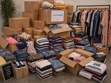 un gros tas de vêtements et de cartons dans une pièce