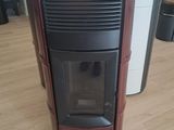 un poêle noir et rouge dans une pièce avec du parquet