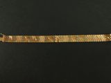 a close up of a gold bracelet on a black surface