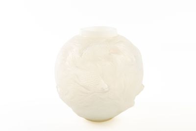 un vase blanc orné d'un oiseau, posé sur une surface blanche