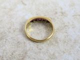 a gold ring with a red stone in it