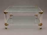a glass and brass coffee table with two shelves on each side
