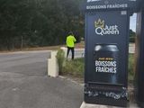 a man standing next to a sign on the side of the road