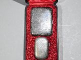 two silver flasks in a red box on a table