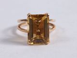 a close up of a yellow gold ring with an emerald stone