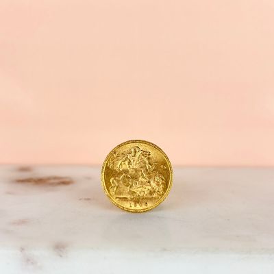 a close up of a gold coin sitting on top of a marble counter