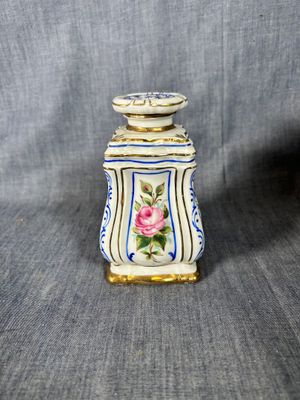 a small vase with a flower on it on a gray background