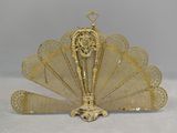 brass plated fan with intricate design on top of it