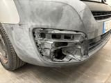 the front bumper of a car with a dent in it