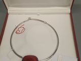 bracelet en argent orné d'un cœur rouge, présenté dans un coffret rouge