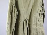 the back of a green jacket hanging on a hanger