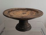 un petit bol en bois posé sur un socle en verre
