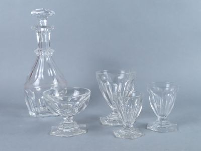 a glass decanter and four wine glasses on a table