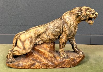 statue of a lion on a rock with its mouth open