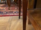 a cat that is sitting on the floor next to a table