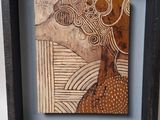 painting of a woman ' s face in a wooden frame on a wall