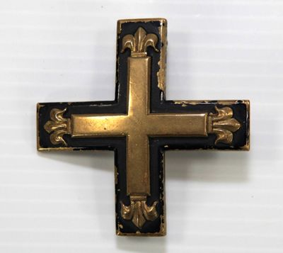 un gros plan d'une croix noire et dorée sur un fond blanc