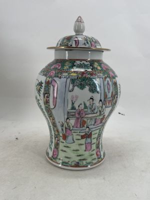 a vase with a lid that has a picture of a woman in a garden