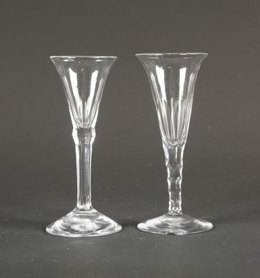 deux verres à vin transparents posés l'un à côté de l'autre sur une table