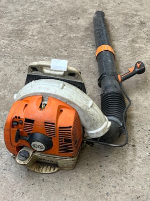 an orange and black blower sitting on the ground next to a blower