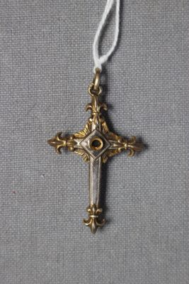 une croix en or suspendue à un cordon blanc