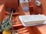 un petit bateau orange rempli de toutes sortes de choses