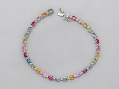 un bracelet multicolore avec un fermoir argenté sur fond blanc