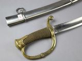 a sword with a gold handle on a white surface