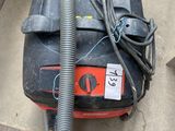 un aspirateur posé par terre à côté d'un sac