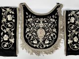 two black and white embroidered bags hanging on a white wall