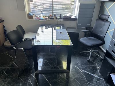 a desk with two chairs and a television in a room