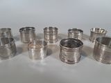 several silver napkins and cups are lined up on a white surface