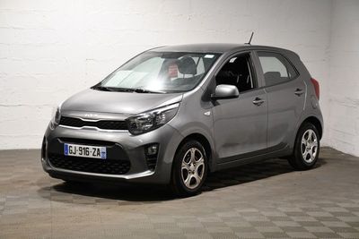 La petite voiture est garée dans une grande pièce au sol carrelé.