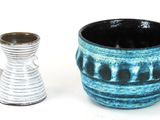 two vases sitting next to each other on a white surface